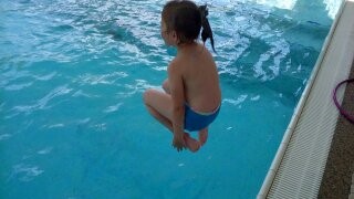 Spass beim Schwimmkurs: Mädchen hüpft ins Wasser